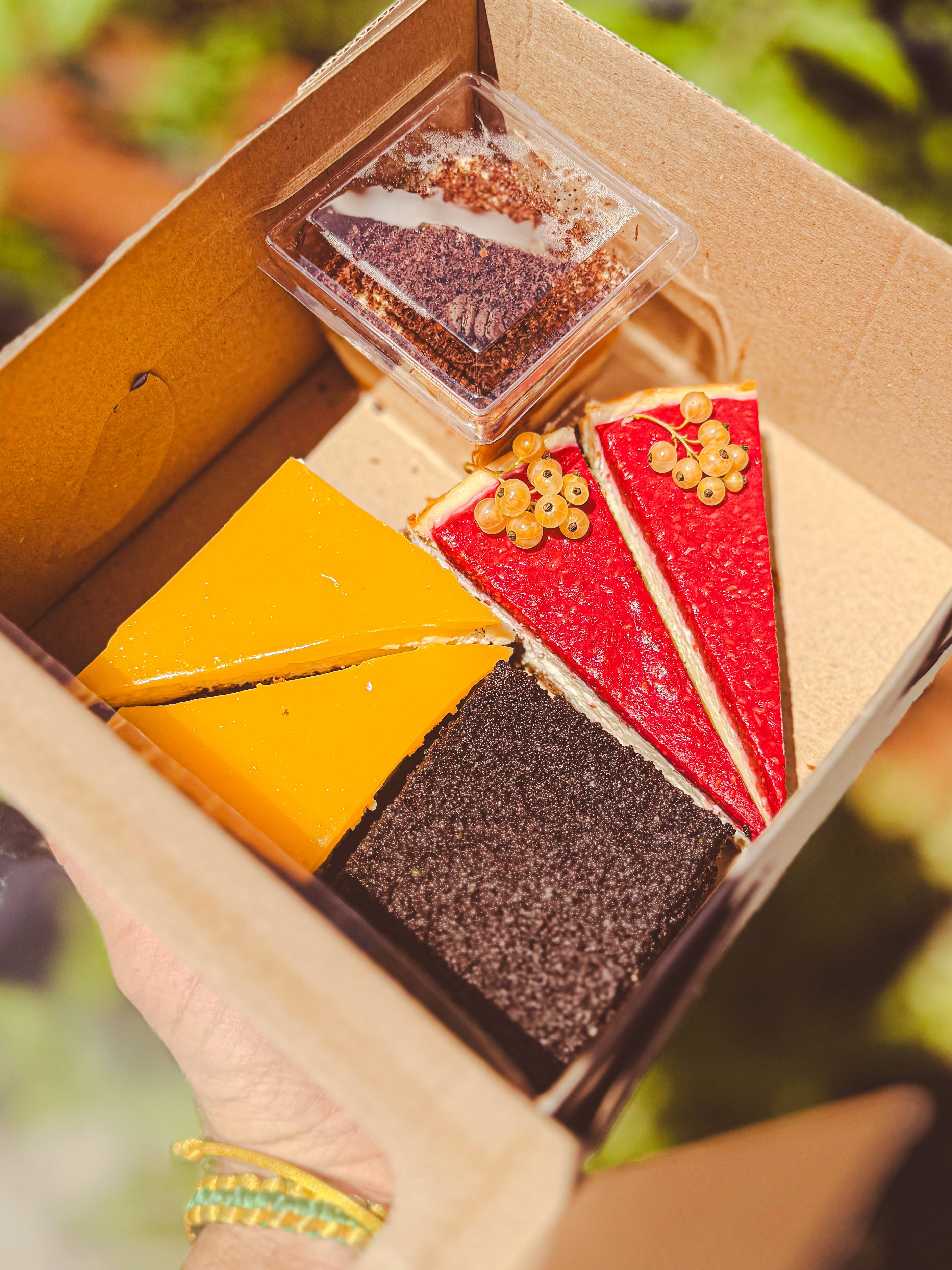 Box so štyrmi koláčikmi — maková kocka, mangový želatínový, jahodovo-malinový cheesecake a marhuľové tiramisu